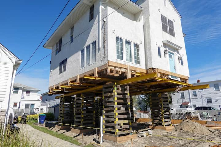 A team of professionals using specialized equipment to raise a house in Worcester, preparing it for elevation and renovation